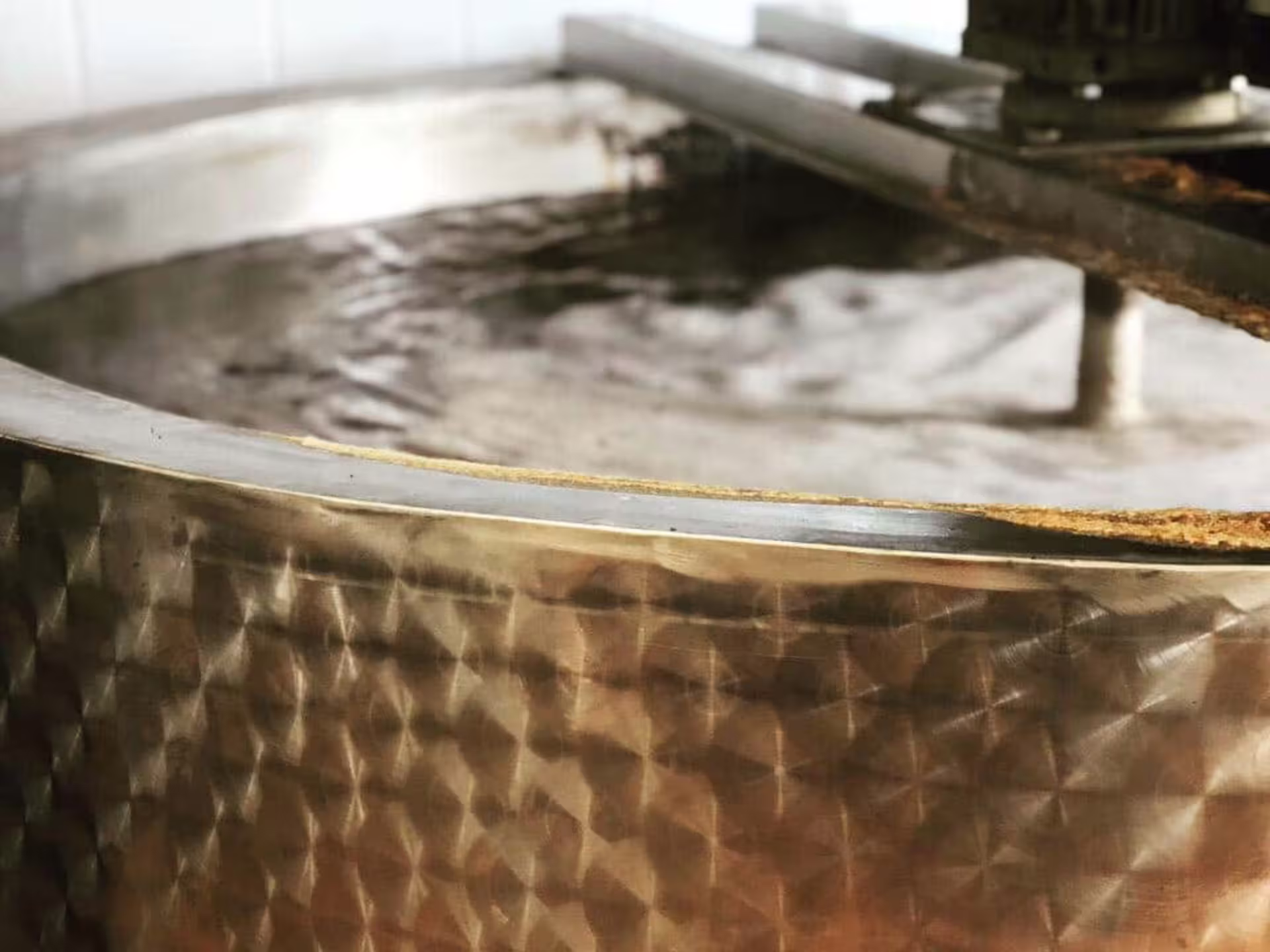 Copper cauldron simmering grape must for traditional balsamic vinegar during Modena production tour