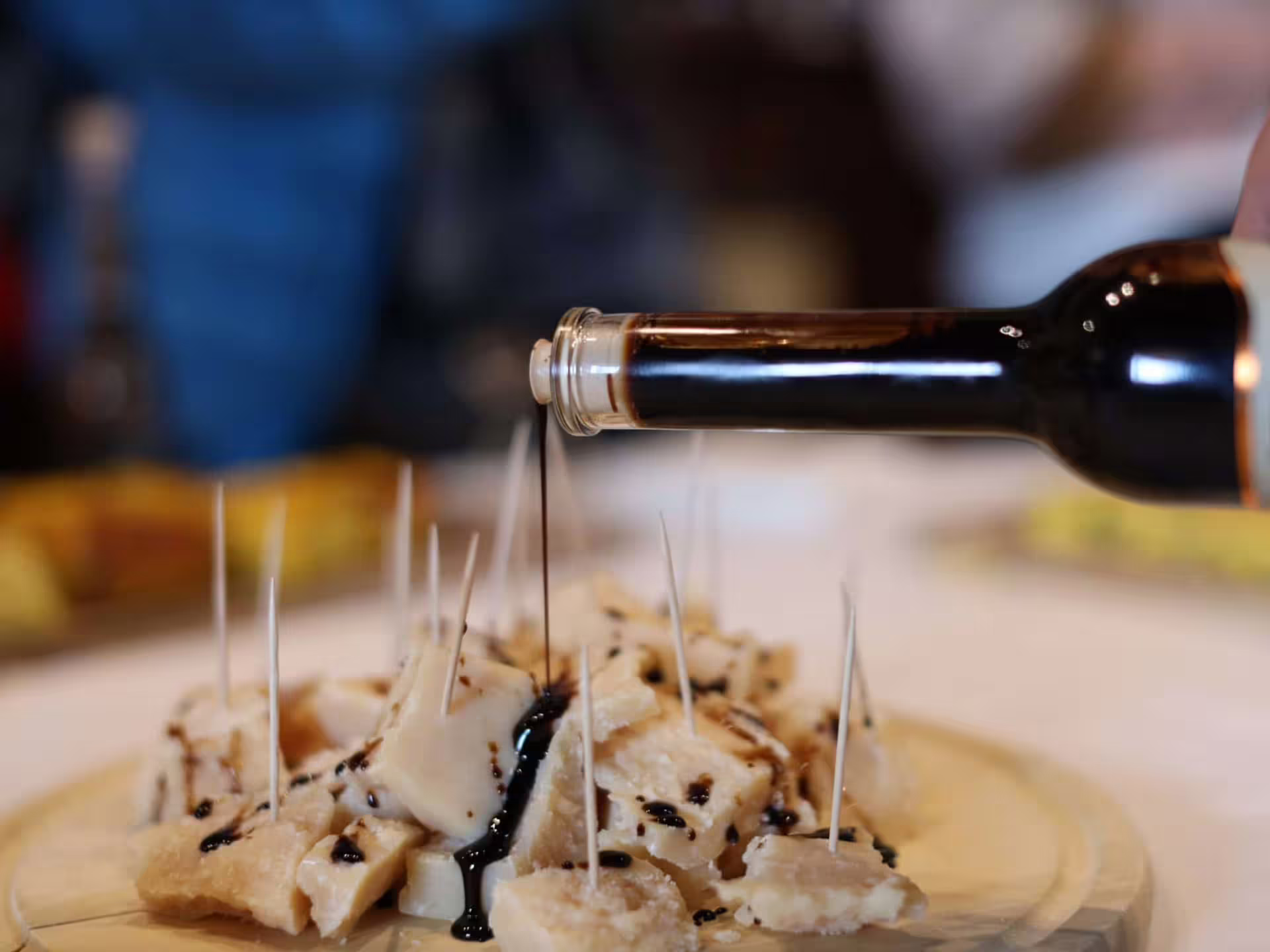 Traditional balsamic vinegar drizzle over Parmigiano bites during Modena tasting and production tour
