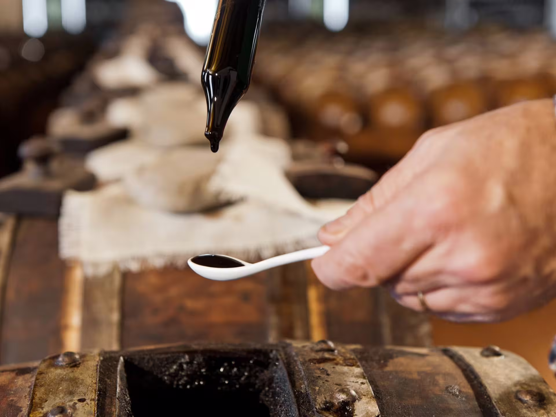 Close-up of balsamic vinegar tasting as a drop is poured into a spoon at a Modena acetaia visit
