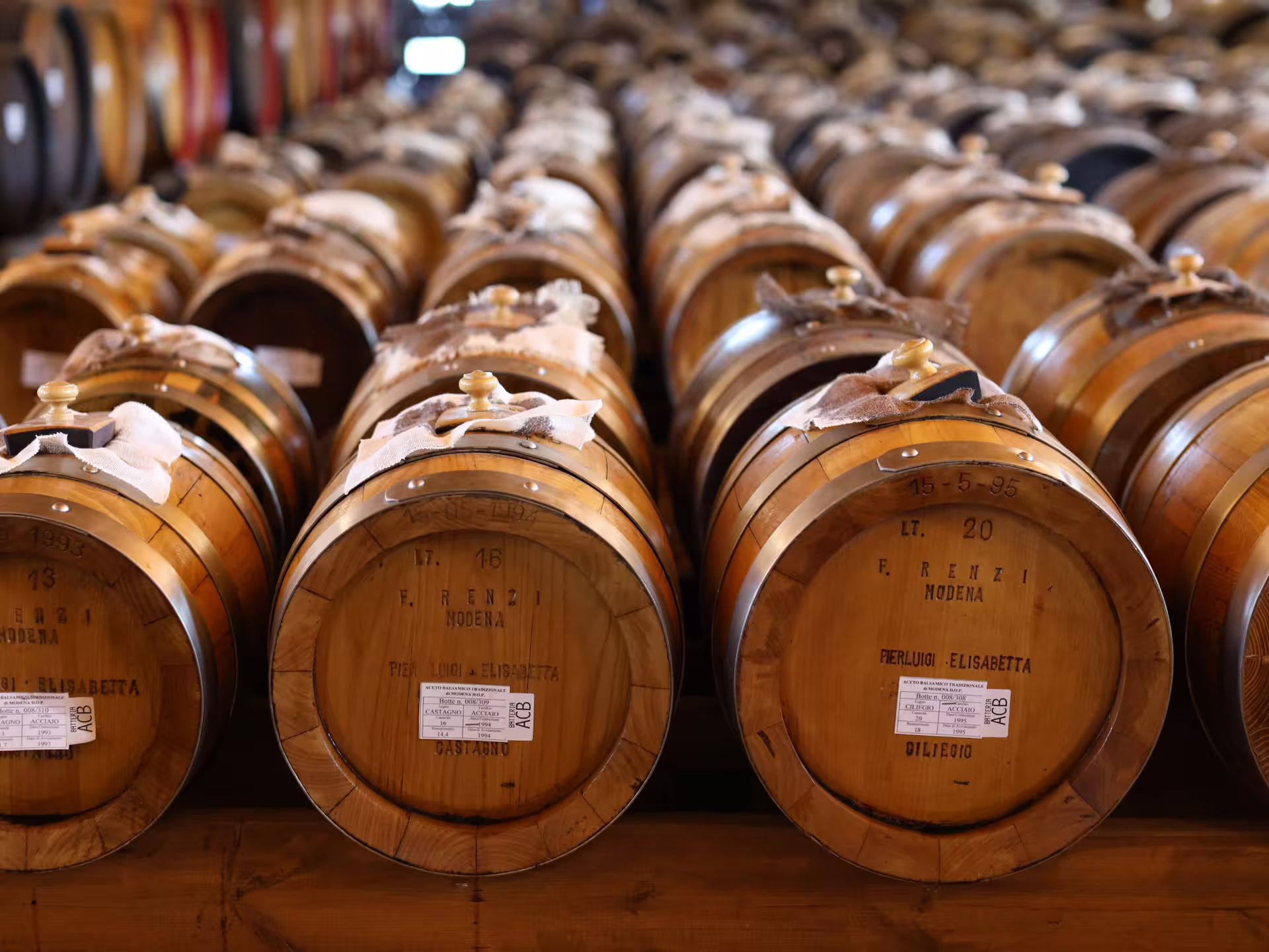 Rows of traditional wooden barrels aging Aceto Balsamico Tradizionale on a Modena production tour