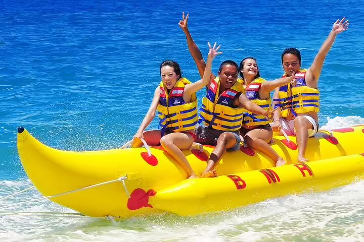 Friends riding banana boat on Red Sea during Hurghada VIP boat trip to Hula Hula Island with snorkeling fun