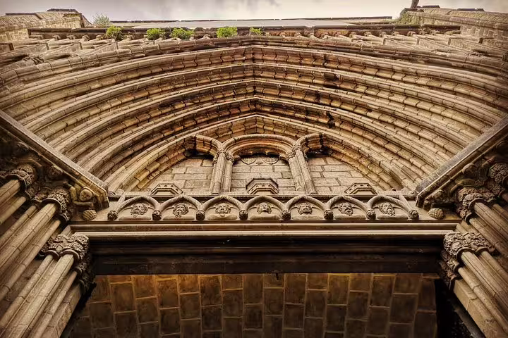 Ornate Gothic archway of Barcelona Cathedral, showcasing intricate medieval architecture, a highlight of private city tours.