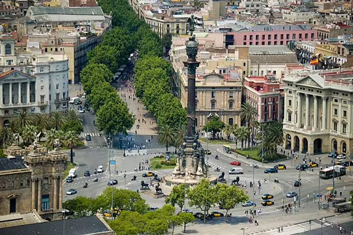 Aerial view of the bustling Columbus Monument and surrounding streets in Barcelona's city center.
