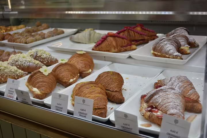 Display of assorted croissants at a Barcelona bakery, highlighting food tasting on the cultural walking tour.