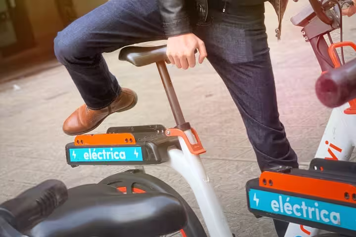 Close-up of a person using an electric bike in Barcelona, showcasing sustainable transportation options on the urban planning tour.