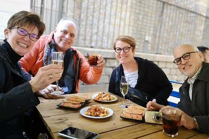 Group enjoying a food and drink tasting with tapas and wine on a private tour in Barcelona, highlighted by Sagrada Familia visit.