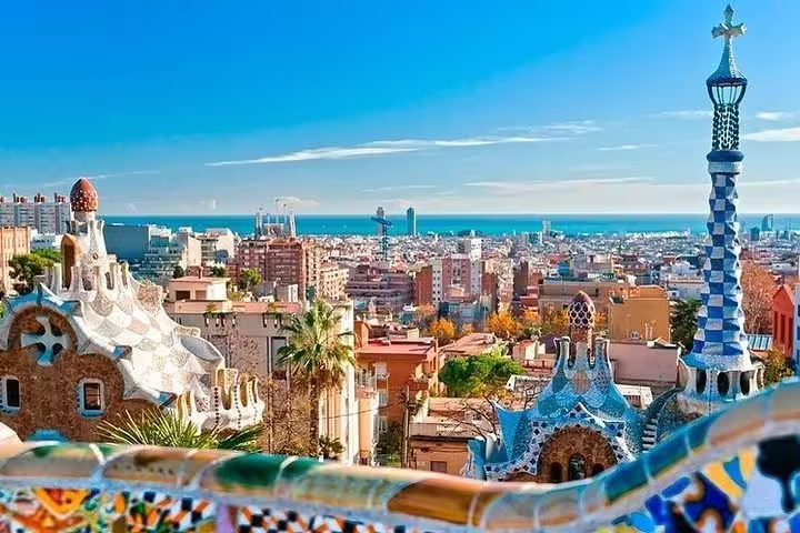 Stunning panoramic view of Barcelona cityscape and Mediterranean Sea from Park Güell, highlighting Gaudí architecture.