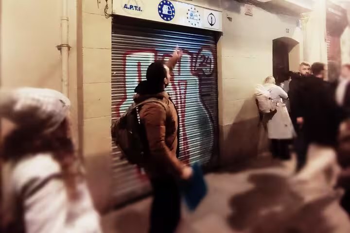 Tour guide leading a group through historic streets for Barcelona Ghosts of a Dark Past Walking Tour at night.