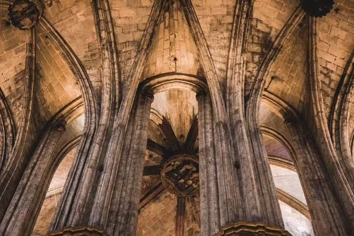 Gothic arches and detailed ceiling inside a historic Barcelona cathedral, ideal for architecture enthusiasts.