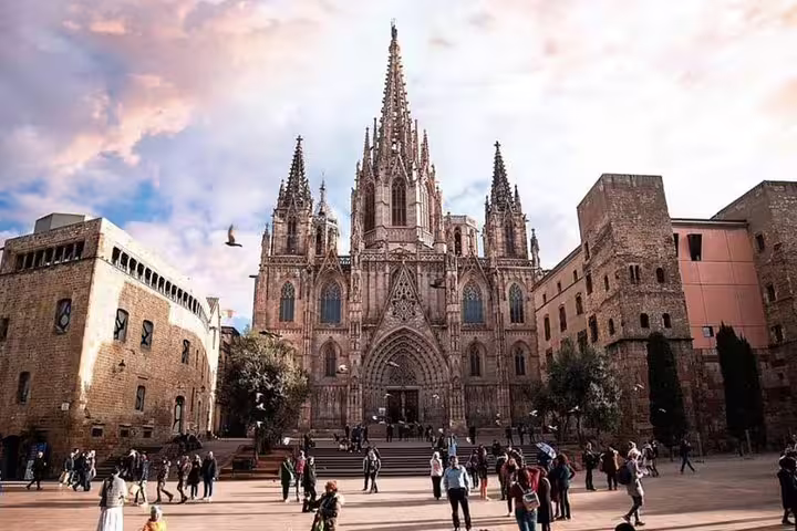 Tourists explore Barcelona's stunning Gothic Quarter, featuring the iconic Cathedral, as part of a walking tour experience.