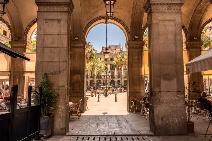 Arched walkway opening to Plaça Reial, seen on a Barcelona Old Town Gothic Quarter and El Born walk
