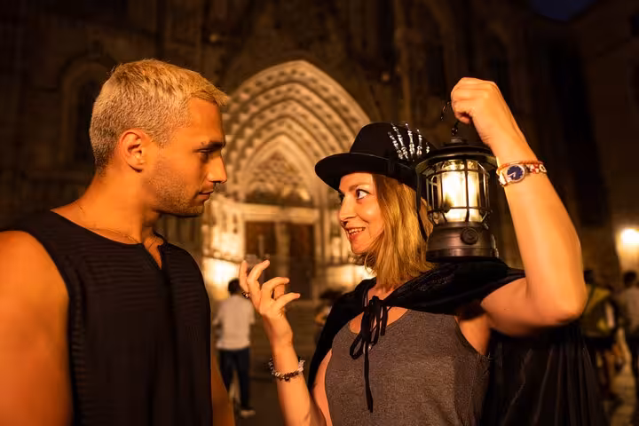 Tour guide shares spooky stories with participant by the Gothic Quarter's historic architecture.