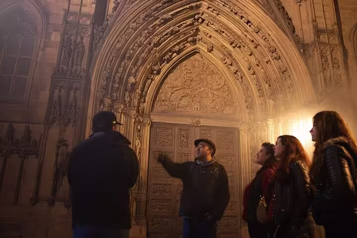 Tour group listening to a guide in front of a Gothic cathedral during the Barcelona Ghost tour.