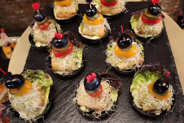 Delight in gourmet tapas featuring fresh greens, olives, and sprouts on a Barcelona food tour with Sagrada Familia skip-the-line access.