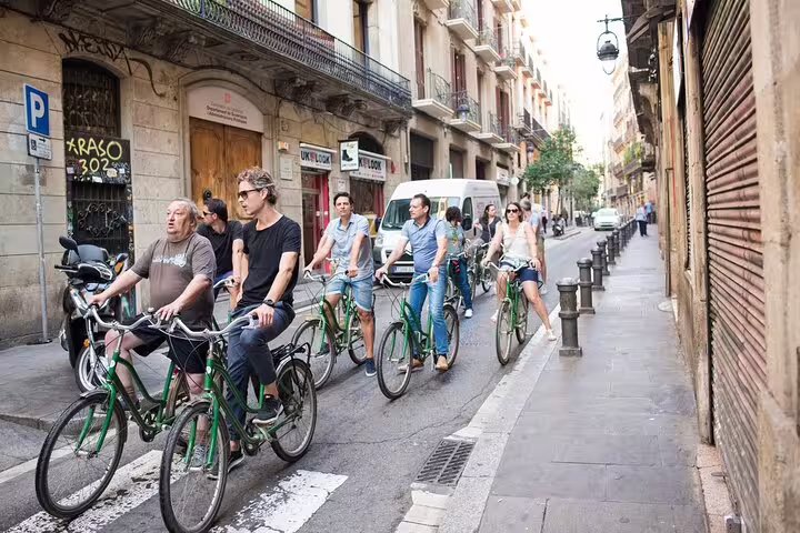 Group of tourists enjoying a guided bike tour through the charming streets of Barcelona, highlighting the city's vibrant atmosphere.