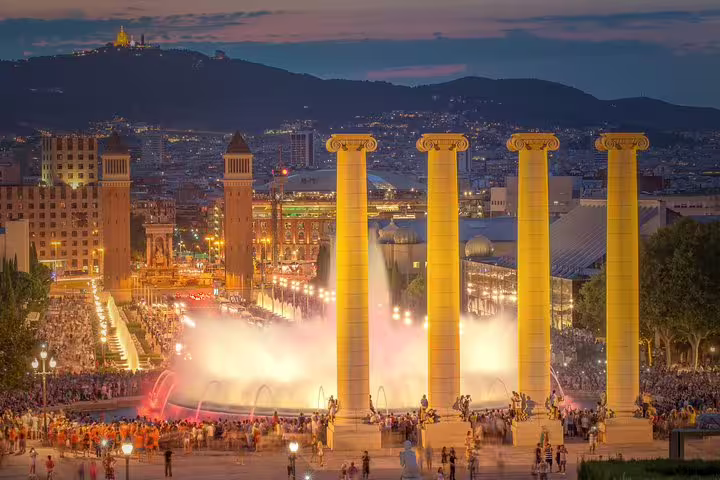 Night view of Barcelona's Magic Fountain, vibrant lights and crowds, ideal for Montserrat and city highlights tour with pickup.