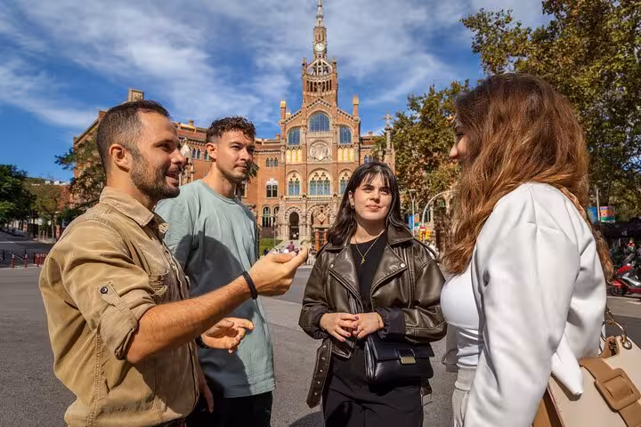 Small group walking tour guide briefing travelers outside Sant Pau Art Nouveau site in Barcelona