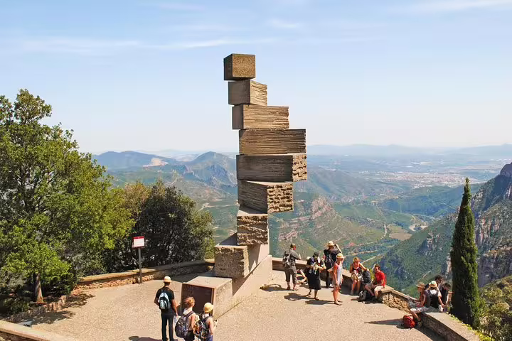 Tourists admire the stunning Montserrat mountain views and unique sculpture during the Barcelona Highlights tour with pickup.