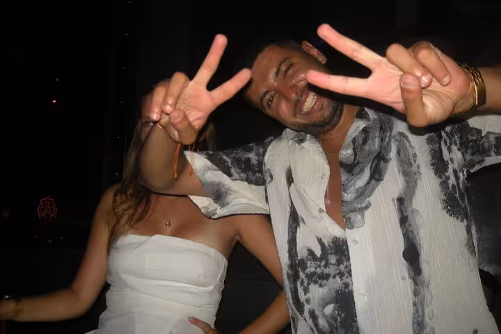 Two friends posing with peace signs, showcasing the energetic atmosphere of a Barcelona nightclub.
