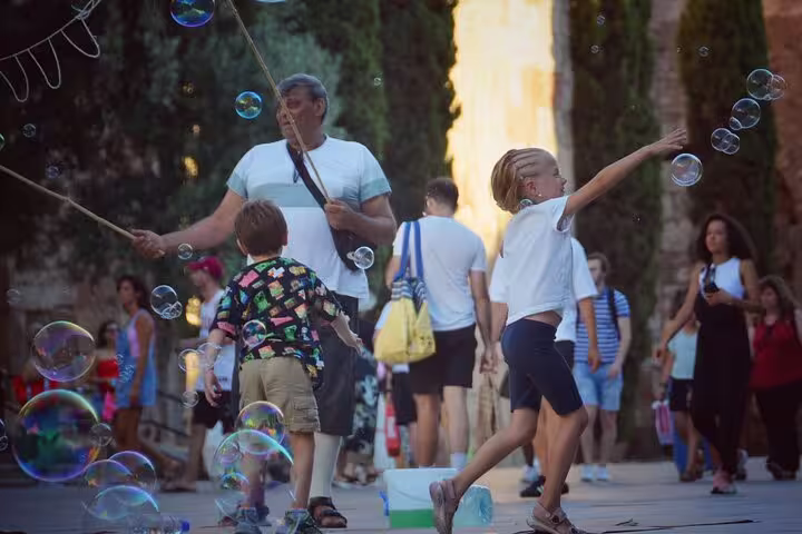 Children play with bubbles in a lively Old Town square, adding joy to the private tour experience.
