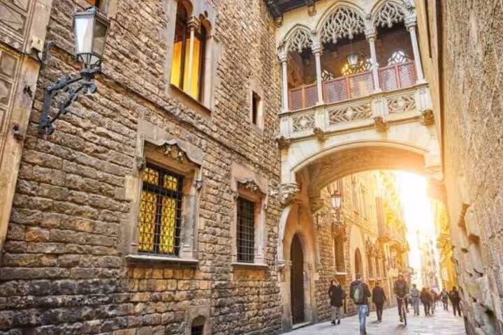 Charming narrow street in Old Town featuring medieval stone buildings and a picturesque archway with sunlight.