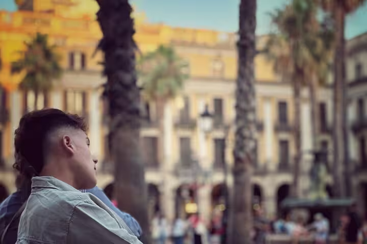 Tourist enjoying the vibrant atmosphere of Old Town with palm trees and historic architecture in the background.