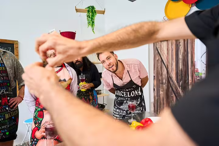 Participants engage in an interactive paella cooking class, learning to prepare authentic Spanish cuisine with expert guidance.