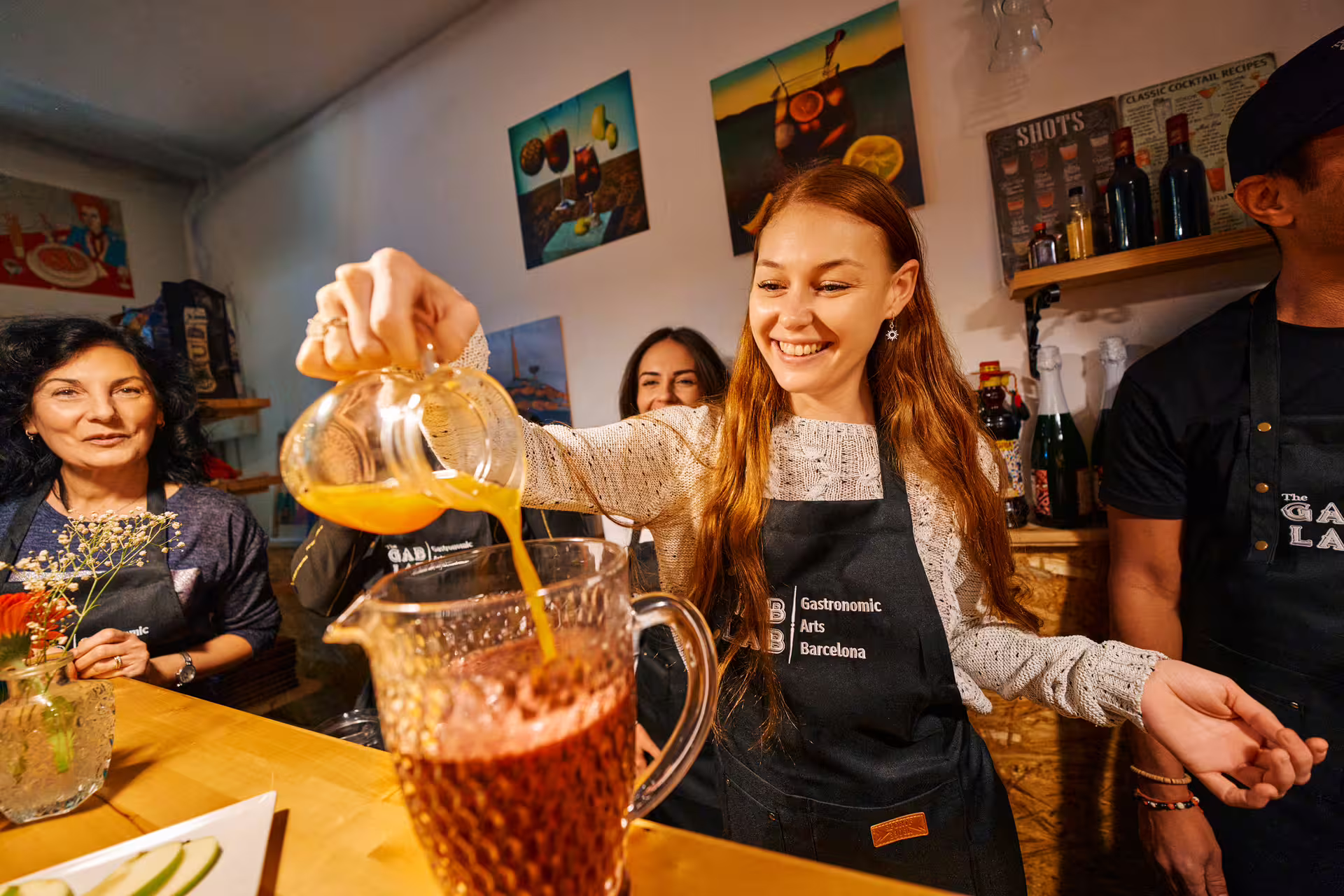 Smiling participants enjoy hands-on experience in a vibrant Barcelona kitchen during the Ultimate Paella Cooking Class.