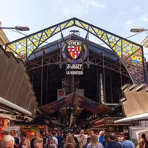 Busy entrance of La Boqueria Market in Barcelona, offering an authentic backdrop for the Ultimate Paella Cooking Class Experience.