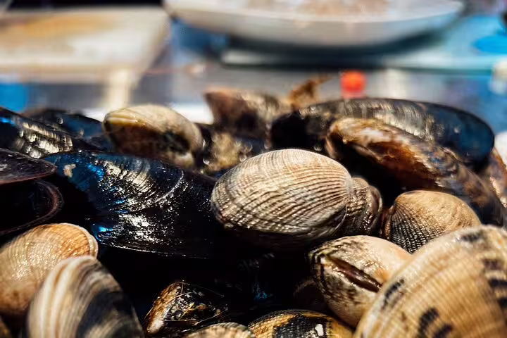 Close-up of fresh mussels and clams ready for cooking in an immersive Ultimate Paella Cooking Class Experience.