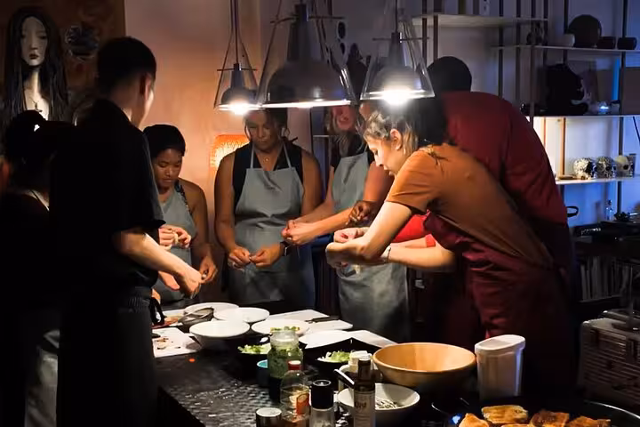 Evening cooking class in Barcelona features participants learning to make authentic paella and sangria in a cozy setting.
