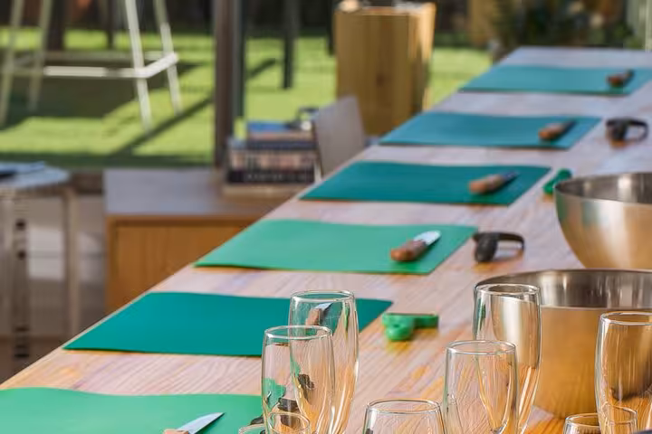 Cooking class setup with green cutting mats and glasses ready for a Barcelona paella and sangria experience.