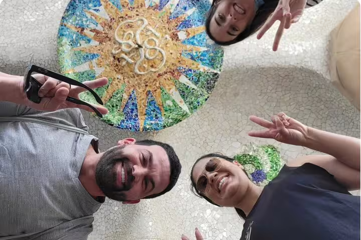 Group enjoying the vibrant mosaic ceiling in Park Güell during a Barcelona VIP private tour.