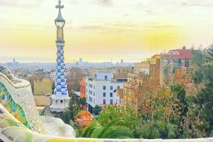 Scenic view of Barcelona from Park Güell with colorful mosaic architecture and cityscape at sunset, perfect for tours.