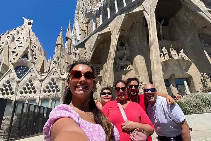 Group of tourists enjoying a sunny day in front of the iconic Sagrada Familia, a highlight of the Barcelona Premium tour.