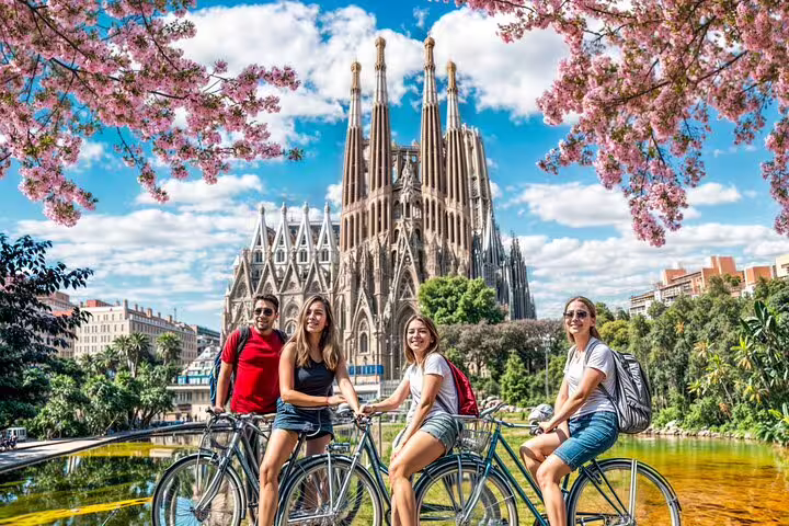 Group enjoying a private bike tour in Barcelona with a view of the iconic Sagrada Familia under a vibrant spring sky.