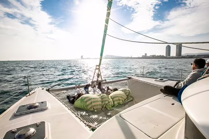 Relax on a private catamaran in Barcelona with snacks and cava, enjoying stunning views and a beautiful sunset over the Mediterranean.