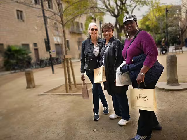 Three tourists enjoy a private walking tour in Barcelona's Raval Quarter, exploring vibrant streets and local culture.