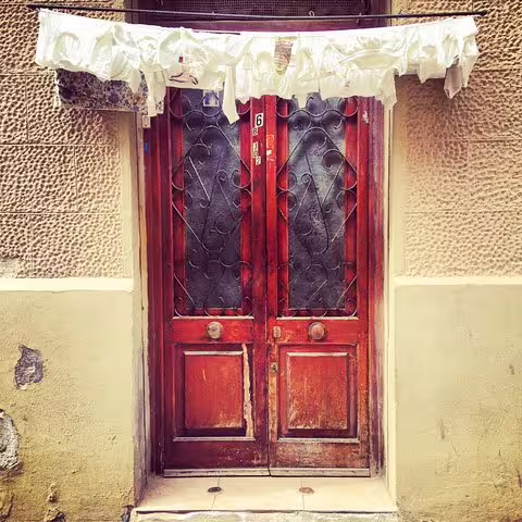 Charming old wooden door in Barcelona's Raval Quarter, highlighting the unique character of the Alternative Walking Tour.