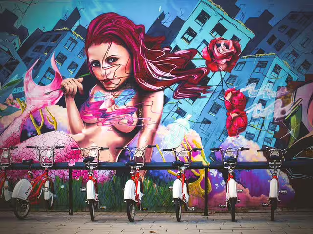 Vibrant street art mural in Barcelona's Raval Quarter depicting a mermaid, with rental bikes in the foreground, on a walking tour.