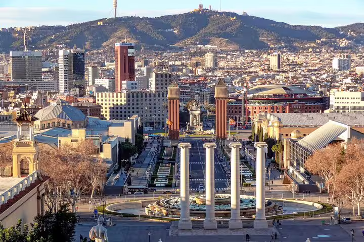 Panoramic view of Barcelona cityscape, highlighting iconic landmarks and Montjuïc hill in the background.