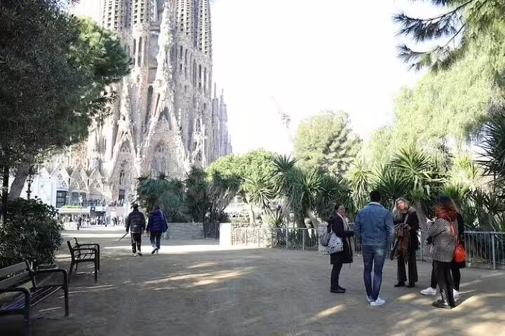 Small group with guide in park beside Sagrada Familia, starting an insider walking tour with skip-the-line access