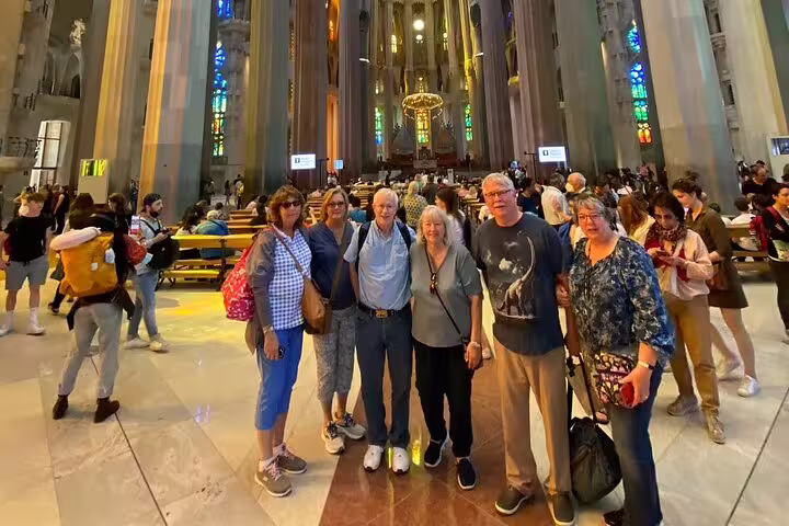 Group of tourists exploring the magnificent interior of Sagrada Familia on a guided Barcelona city tour.