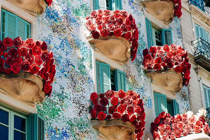 Colorful facade with red rose balconies and mosaic tiles in Barcelona's architectural tour highlights.