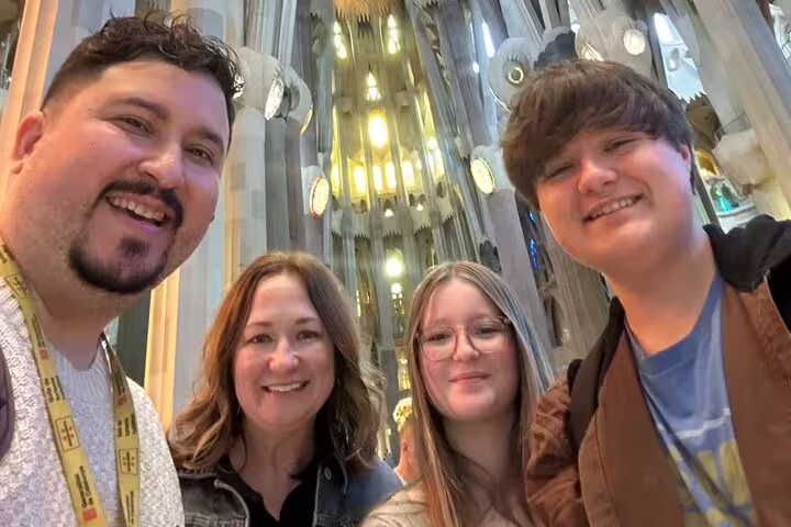Visitors smiling inside the illuminated Sagrada Familia on a Barcelona VIP private tour.