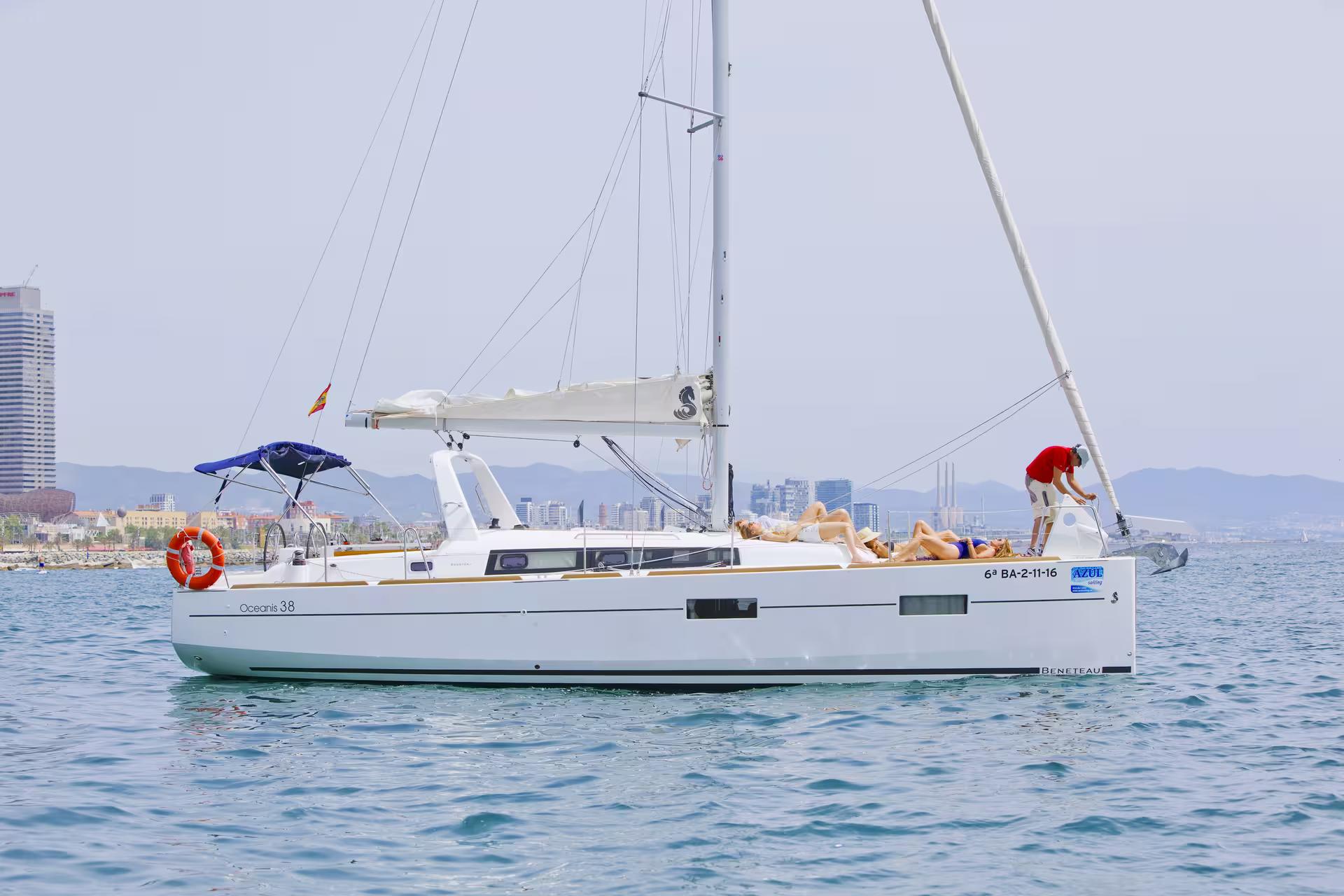 Sailing yacht cruising off Barcelona coastline on 1-hour refreshing tour with open bar and snacks onboard