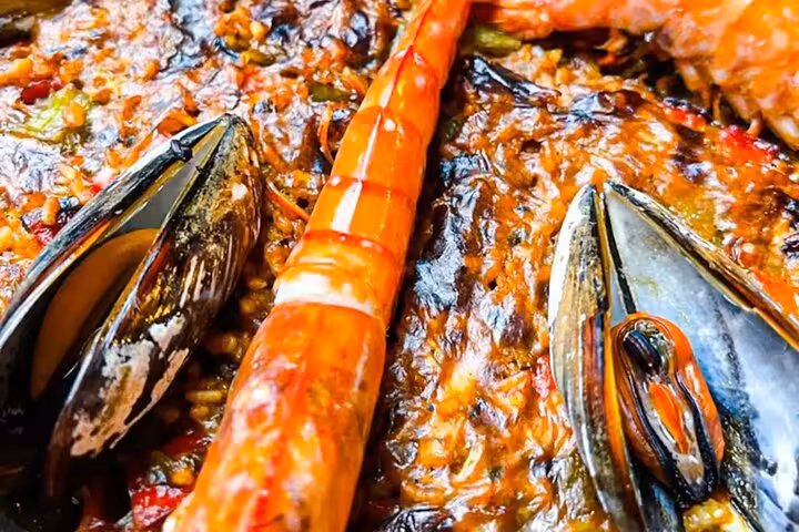 Close-up of a vibrant seafood paella with mussels and prawns, highlighting authentic Spanish culinary experience.