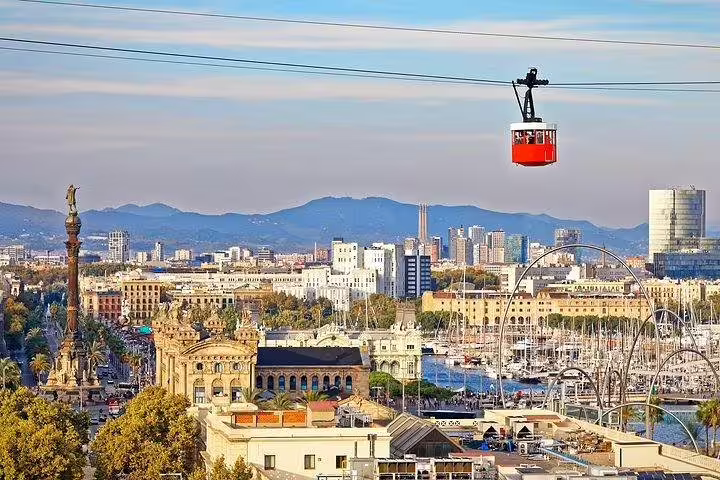 Scenic view of Barcelona skyline with cable car, harbor, and Columbus Monument, ideal for private tours with tapas and drinks.