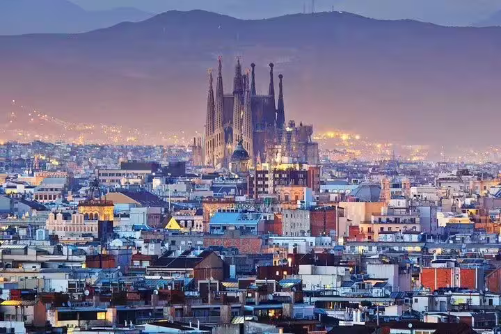Stunning aerial view of Barcelona skyline featuring Sagrada Familia at dusk, highlighting the Lisbon to Barcelona transfer experience.