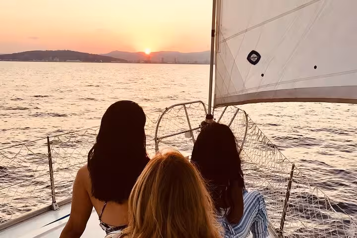 Guests on private sailboat at Barcelona sunset, romantic sailing tour with live saxophone and open bar